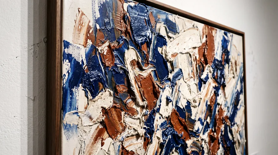 Luz rasante sobre la pintura espesa de un gran lienzo abstracto